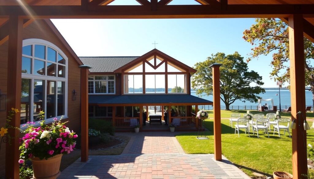 A picturesque view of Brady Lodge, an elegant event venue nestled in Bay Court Park. In the foreground, a charming wooden entrance adorned with welcoming flowers invites guests. In the middle, the lodge itself offers large windows, rustic wooden beams, and a spacious, sunlit porch that enhances the inviting atmosphere. To the right, a well-maintained lawn is set up for a wedding ceremony, complete with white chairs and floral decorations, while to the left, a family reunion is depicted under festive canopies. The background showcases serene waterfront views, trees lining the shore under a clear blue sky. The scene is bathed in soft, warm sunlight, conveying a cheerful and welcoming mood. Shot at a slight angle from the front, emphasizing the lodge and its surroundings in an idyllic, engaging manner.